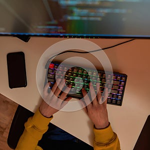 Top view of IT developer typing code on computer