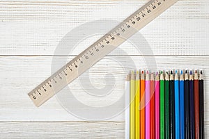 Top view of different colored wooden pencils with centimeter ruler