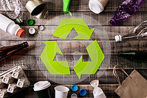 Top view of Different garbage materials with recycling symbol on table background. Recycle, environment and Eco concept