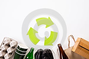 Top view of Different garbage materials with recycling symbol on white wooden table background. Recycle, World Environment Day and