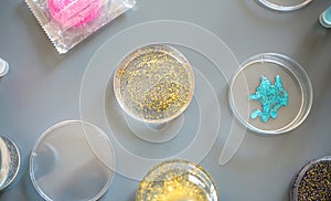 Top view of different glitter samples in petri dishes over a lab table background