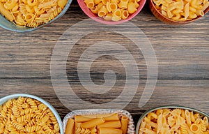 top view of different macaronis as pipe-rigate rotini ziti and others on wooden background with copy space