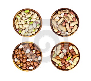 Top view of different nuts mix set: almonds, pistachios, peanuts, hazelnuts heap in round brown wooden bowl isolated on white