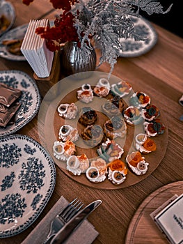 Top view of different snacks on round wooden tray