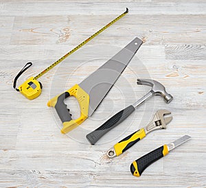 The top view of different working tools lying on wooden workbench