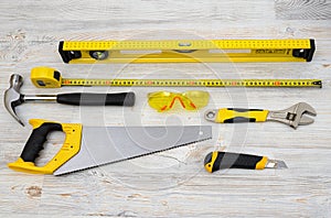 The top view of different working tools lying on wooden workbench