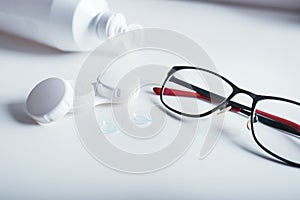 Top view of dioptric red-black glasses  white cover for contact lenses and lenses on a white background. Concept of medicare.