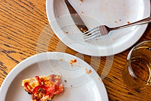 Top view of dirty messy plates after pizza eating with unclean used utensils in the cafe. photo