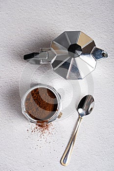 Top view of a disassembled geyser coffee maker with ground coffee