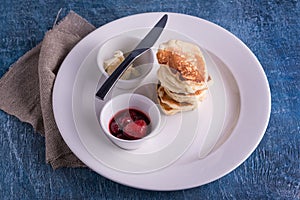 Top view dish with pancakes and knife and butter and strawberry