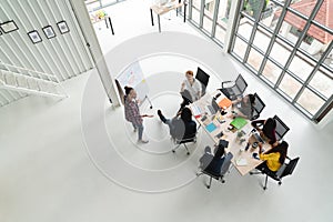 Top view of diverse people of creative team group using smartphone, mobile phone, tablet and computer laptop while meeting.