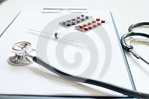 Top view of doctor desk table with stethoscope and notepad with