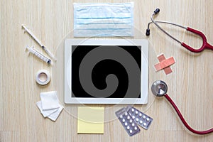 Top view of doctors desk with tablet and medical appliance