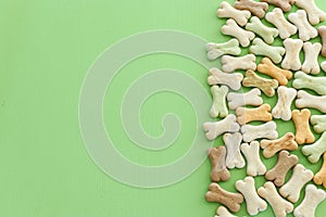 Top view of dog treats over green wooden background