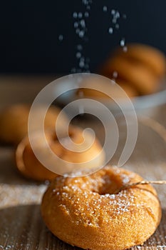 Top view of donuts on bokeh with black background and sugar straying