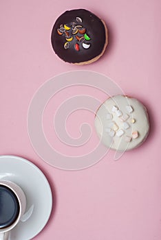 Top view Doughnuts with Icing and cup of Coffee, on Pastel Pink Background. Sweet Dessert Donuts with Copy Paste.