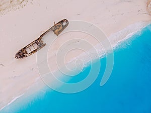 Top view down on an old rusty ship lying on the beach.