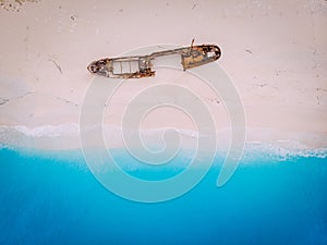 Top view down on an old rusty ship lying on the beach.