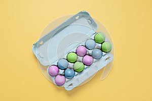 Top view of dozen dyed easter eggs in egg carton container