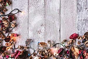 Top view of Dried flowers with Christmas lights on wooden table background. Free space for your text.