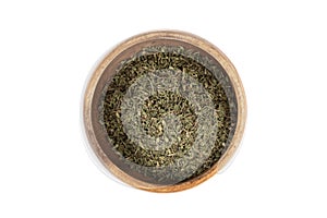 Top view of dried thyme herb in wooden bowl on white background.