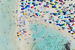 Top view from drone at beach and azure sea. Aerial view on beach, people and umbrellas.