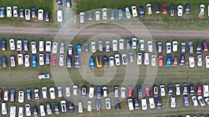 Top view from a drone of cars parked on the lawn.