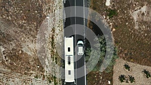 Top view drone tracking white car moving along beautiful white rocky landscape road pattern in summer Cappadocia Turkey.