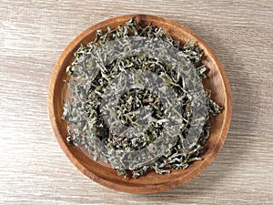 Top view of dry mugwort on wooden plate. Chinese medicine.