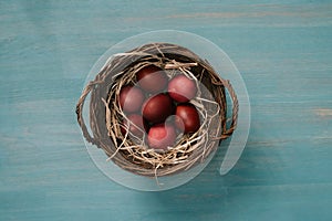 top view of easter basket with painted eggs and straw