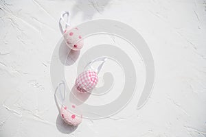 Top view of easter eggs colored with pink paint in differen patterns. Various striped and dotted designs. White