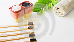 Top view Eco friendly natural bamboo toothbrush,with green leaf natural place on towel a white background, concept reduce use