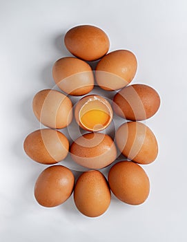 Top view of Egg yolk in Broken raw chicken eggshell in the among of Fresh chicken egg on white background