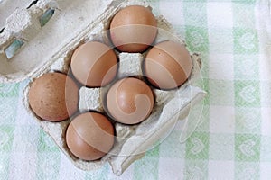 Top view of eggs in the carton on the table