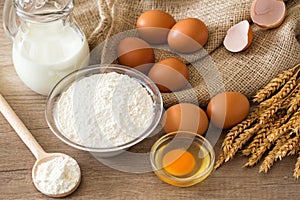 Top view eggs, flour and baking ingredients on wooden table