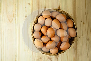 Top View of eggs put in a wicker basket in wooden background