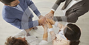Top view of employees stack hand in teambuilding activity