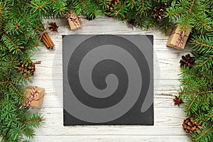 Top view. Empty black slate square plate on wooden christmas background. holiday dinner dish concept with new year decor