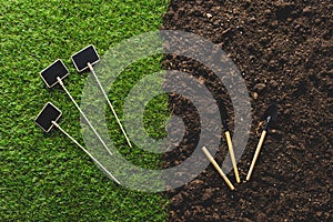 top view of empty blackboards on grass and gardening tools on soil