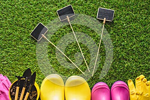 top view of empty blackboards, rubber boots, protective gloves, flower pot