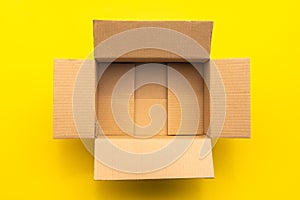 Top view empty brown post or carton box on yellow paper background