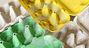 Top view of empty egg cartons. green, grey and yellow egg trays