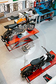 Top view of empty motorcycle workshop with custom motorbikes over platforms ready to review