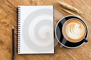 Top view empty notebook and coffee cup on wooden table top view