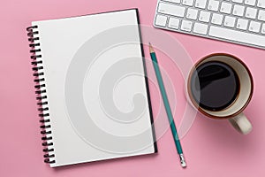 Top view, empty notebook and office supplies on desk pink background