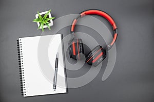 Top view of empty notebook with red headphone on black background