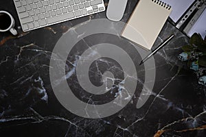 Empty notepad, wireless keyboard and mouse on marble background.