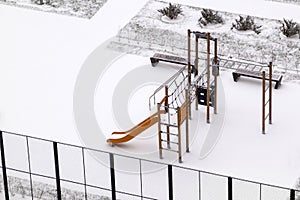 Top view of empty slide on winter Playground covered with snow