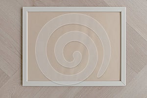 Top view of empty space of white photo frame, putting on wooden floor.