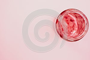 Top view of an empty strawberry jam jar isolated on light pink background